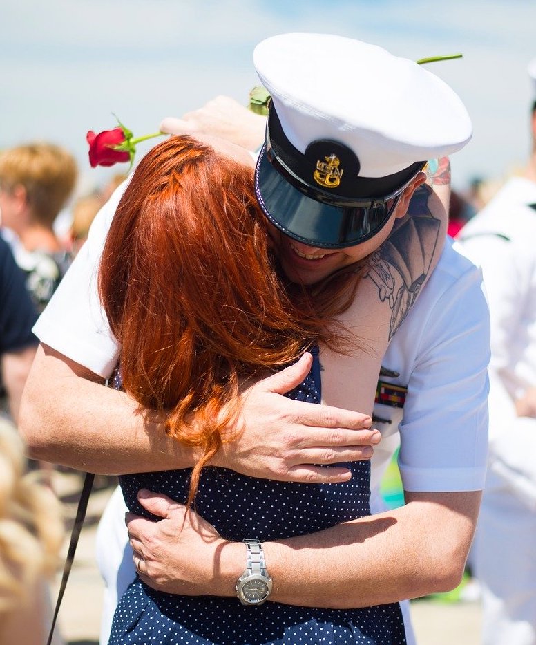 Navy officer embracing loved one after homecoming